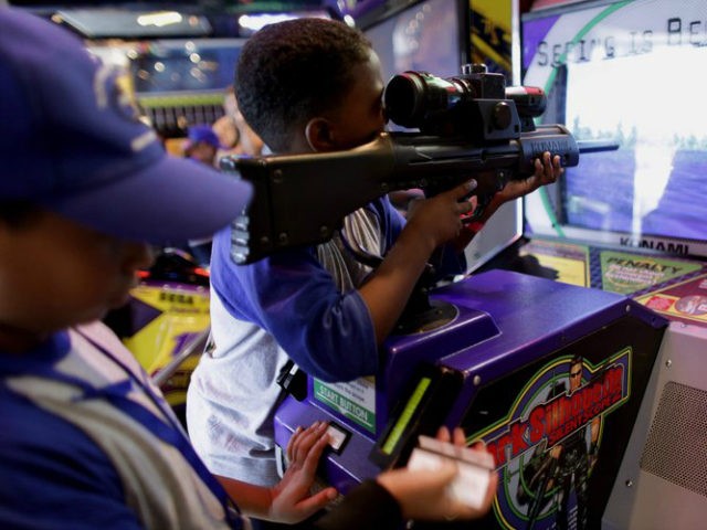 In this photo taken Sept. 2, 2009, a boy, using a toy weapon, plays a video game in Caracas. Venezuela's National Assembly is on track to prohibit violent video games and toys. The proposed legislation, which received initial approval in September, is expected to get a final vote in the …