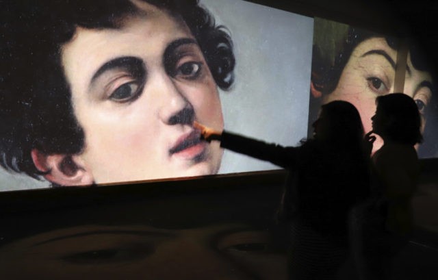 Mexico Caravaggio Visitors look at a projection of a painting by Italian master Michelangelo Merisi da Caravaggio (1571 1610) during the opening of a Caravaggio exhibit at the National Art Museum in Mexico City Wednesday Feb. 21, 2018. (AP Photo/Bernandino Hernandez) The Associated Press