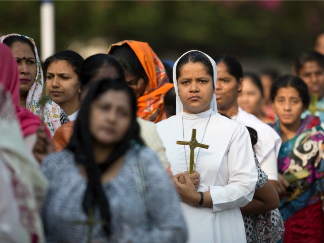 A Christian nun holds a crucifix during a Good Friday procession in Hyderabad, India, Friday, March 30, 2018. Christians all over the world attend mock crucifixions and passion plays that mark the day Jesus was crucified, known to Christians as Good Friday. (AP Photo/Mahesh Kumar A.)