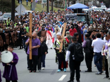 Thousands of people follows actors as they portray Jesus Christ and Roman centurions during a traditional Via Crucis, or Way of the Cross, procession on the Christian Good Friday holiday March 30, 2018 in Takoma Park, Maryland. The re-enactment of the crucifixion of Jesus drew several thousand area Catholics and …