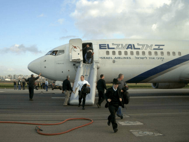 Passengers and crew members flee away of an El Al aircraft at Ben Gurion International Air