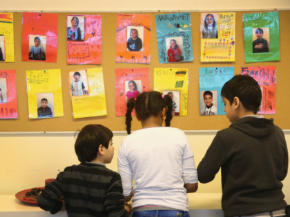 BERLIN, GERMANY - JANUARY 07: Children play under photographs of fellow pupils at the 'Welcome Class' for immigrant children, including children of migrants and refugees, at the Leo-Lionni-Schule primary school on January 7, 2016 in Berlin, Germany. Germany is investing in German language classes across the country by hiring more …