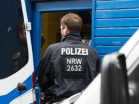 A policeman waits on August 10,2016 in Duisburg in front of a Turkish travel office. Police conducted searches in different locations of the German state of the North Rhine-Westphalia in relation to the Islamc State group connections. / AFP / dpa / Marcel Kusch / Germany OUT (Photo credit should …