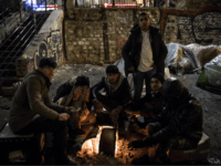 GettyImages-934988440 Migrants, mostly from Afghanistan, warm themselves up around a bonfire in freezing temperatures, by their tents at a makeshift camp set up along the canal Saint-Martin in Paris on March 19, 2018. / AFP PHOTO / CHRISTOPHE ARCHAMBAULT (Photo credit should read CHRISTOPHE ARCHAMBAULT/AFP/Getty Images)