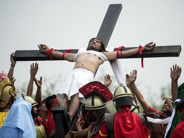 Ruben Enaje, 57, a Christian devotee reacts as he is nailed to a cross during a reenactment of the crucifixion of Jesus Christ during Good Friday celebrations ahead of Easter in the village of Cutud near San Fernando, north of Manila on March 30, 2018. / AFP PHOTO / NOEL …