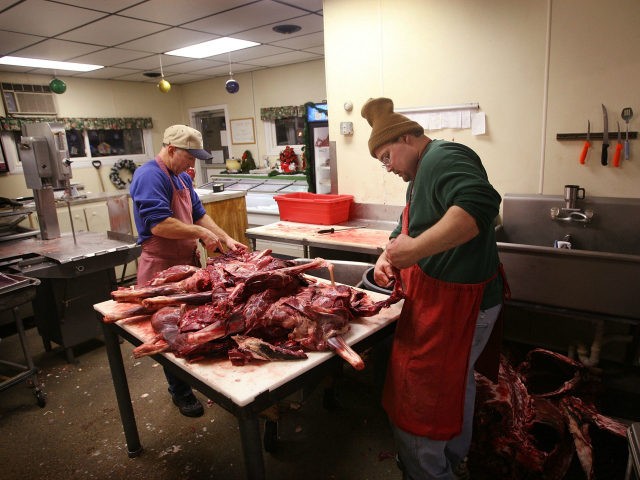 Ralph Roloff (L) and Kevin Metzger trims meat from deer that have been donated to the Help
