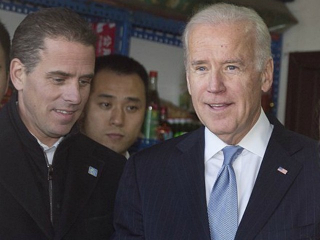 U.S. Vice President Joe Biden, center, buys an ice-cream at a shop as he tours a Hutong alley with his granddaughter Finnegan Biden, right, and son Hunter Biden, left, in Beijing, China Thursday, Dec. 5, 2013. (AP Photo/Andy Wong, Pool)