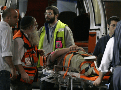 A wounded man is wheeled into a hospital in Jerusalem following a shooting attack on a rel
