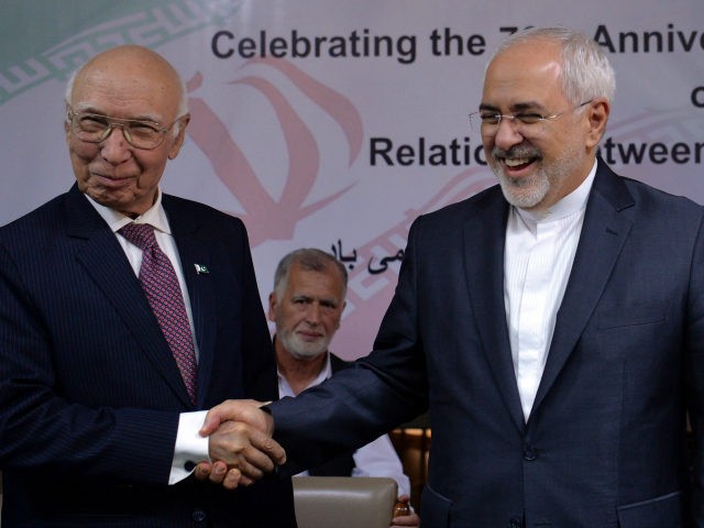 Iranian Foreign Minister Mohammad Javad Zarif (R) shakes hands with Deputy Chairman of Pak