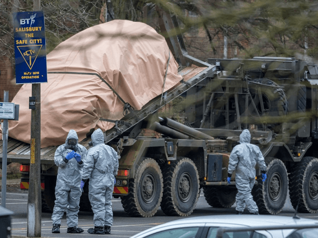 SALISBURY, ENGLAND - MARCH 11: Military personnel wearing protective suits remove a police car and other vehicles from a public car park as they continue investigations into the poisoning of Sergei Skripal on March 11, 2018 in Salisbury, England. Sergei Skripal who was granted refuge in the UK following a …
