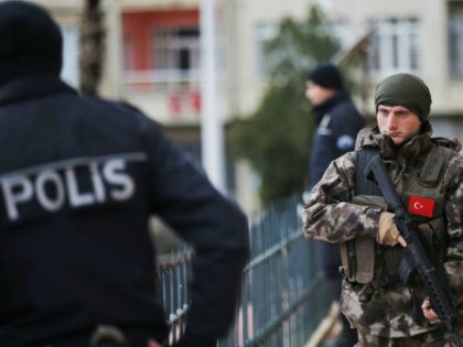 A Turkish special police officer patrols a mosque during the funeral procession for two vi