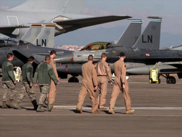 U. S. Air Force airmen walk toward fighter jets after Defense Secretary Ash Carter visited