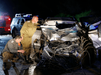 Israeli security forces and forensics inspect the destroyed vehicle that was used by a Palestinian assailant in a car ramming attack targeting a group of Israeli soldiers near Mevo Dotan in the north of the occupied West Bank on March 16, 2018. / AFP PHOTO / Jack GUEZ (Photo credit …