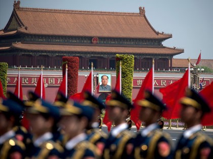 The portrait of late communist leader Mao Zedong is seen behind a Chinese military honour guard as they wait for the start of a welcome ceremony for Cambodia's Prime Minister Hun Sen outside the Great Hall of the People in Beijing on May 16, 2017. Hun Sen is on a …
