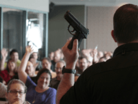 guns school weapon concealed carry pistol Firearm instructor Clark Aposhian holds a handgun up as he teaches a concealed-weapons training class to 200 Utah teachers on December 27, 2012 in West Valley City, Utah. The Utah Shooting Sports Council said it would waive its $50 fee for concealed-weapons training for Utah teachers. (Photo by George Frey/Getty …
