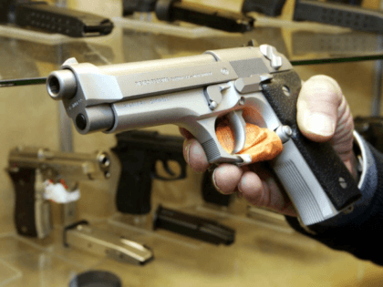 A shop attendant holds a pistol at a guns shop in Naples, southern Italy, Tuesday, Jan. 24, 2006. Provoking protests, Italian lawmakers Tuesday approved a self-defense bill allowing citizens to use guns and other weapons to protect their property at home or at work as well as to save their …