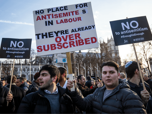 Protesters hold placards as they demonstrate in Parliament Square against anti-Semitism in the Labour Party on March 26, 2018 in London, England. The Board of Deputies of British Jews and the Jewish Leadership Council have drawn up a letter accusing Labour Leader Jeremy Corbyn of failing to address anti-Semitism in …