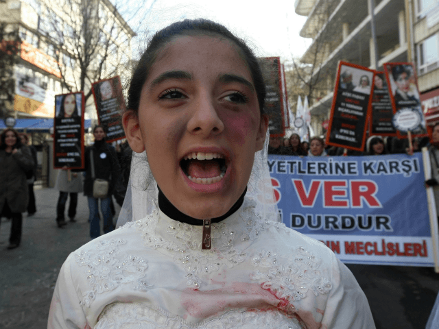 A Turkish girl, wearing a wedding dress and covered with fake bruises, shouts in front of