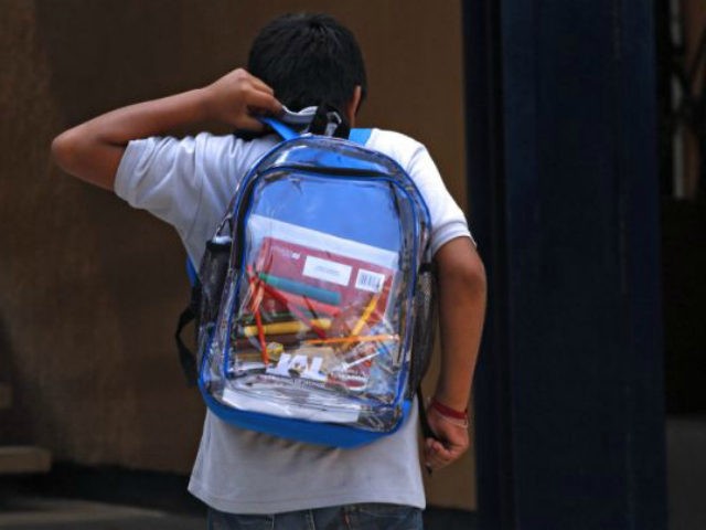 A secondary school student walks carrying his new transparent backpack in Guadalajara, Mex