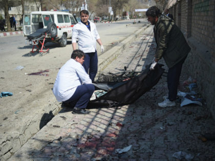Afghan medical staff recover a dead body at the site of a suicide bombing attack in Kabu on March 21, 2018. A suicide bomber on March 21 killed at least 26 people, many of them teenagers, in front of Kabul University, officials said, as Afghans took to the streets to …