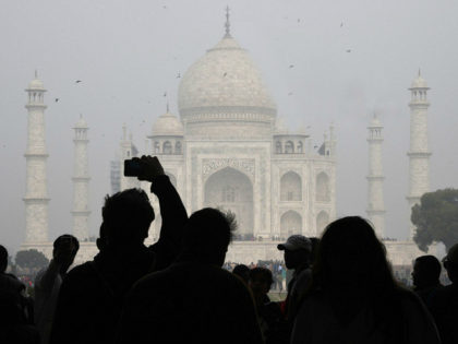 TOPSHOT - Visitors take a photo in front of the Taj Mahal in Agra on January 3, 2018. Indi