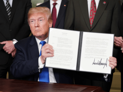 US President Donald Trump signs trade sanctions against China on March 22, 2018, in the Diplomatic Reception Room of the White House in Washington, DC, on March 22, 2018. Trump will impose tariffs on about $50 billion in Chinese goods imports to retaliate against the alleged theft of American intellectual …