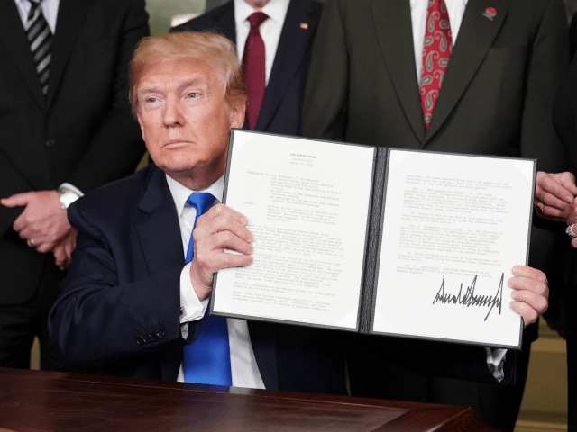 US President Donald Trump signs trade sanctions against China on March 22, 2018, in the Diplomatic Reception Room of the White House in Washington, DC, on March 22, 2018. Trump will impose tariffs on about $50 billion in Chinese goods imports to retaliate against the alleged theft of American intellectual property, White House officials said Thursday. / AFP PHOTO / Mandel NGAN (Photo credit should read MANDEL NGAN/AFP/Getty Images)