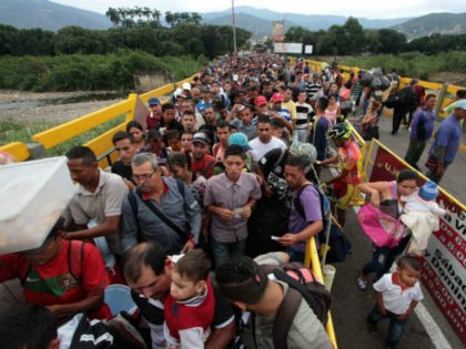 Venezuelan citizens cross the Simon Bolivar international bridge from San Antonio del Tachira in Venezuela to Norte de Santander province of Colombia on February 10, 2018. Oil-rich and once one of the wealthiest countries in Latin America, Venezuela now faces economic collapse and widespread popular protest. / AFP PHOTO / …