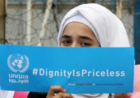A Palestinian refugee holds a placard at a school belonging to the United Nations Relief and Works Agency for Palestinian Refugees (UNRWA) in the town of Sebline in Lebanon, on March 12, 2018, during a protest against US aid cuts to the organisation. A Palestinian refugee holds a placard at a school belonging to the United Nations Relief and Works Agency for Palestinian Refugees (UNRWA) in the town of Sebline in Lebanon, on March 12, 2018, during a protest against US aid cuts to the organisation.