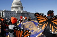 APTOPIX Immigration Congress Wearing "butterfly wings," supporters of the Deferred Action for Childhood Arrivals (DACA) program hold a tarp with an image of President Donald Trump as they march in support of DACA, Monday, March 5, 2018, on Capitol Hill in Washington. (AP Photo/Jacquelyn Martin) DACA deadline for US immigrants arrives with less urgency