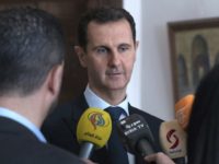 Syria Bashar Assad This photo provided by the official Facebook page of the Syrian Presidency, Syrian President Bashar Assad, center, speaks with reporters, in Damascus, Syria, Sunday, March 4, 2018 . Assad vowed Sunday to continue with a military offensive in a rebel held region near the capital, as troops and allied militias captured a number of villages and towns in the besieged region, in their largest advance since a wide scale operation began last month. (Syrian Presidency Facebook Page via AP) Bashar Assad