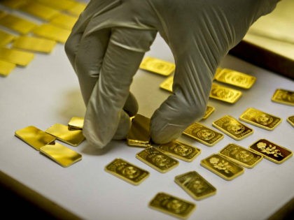 In this Tuesday Oct. 9, 2012 photo, a gold press operator collects 10 gram gold blanks to
