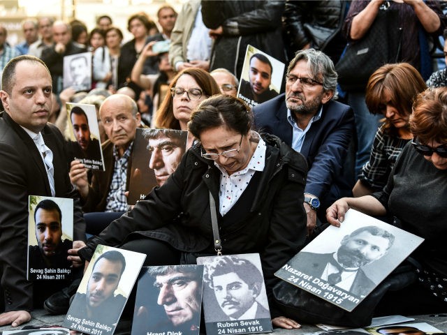 People hold portraits of Armenian intellectuals - who were detained and deported in 1915 -