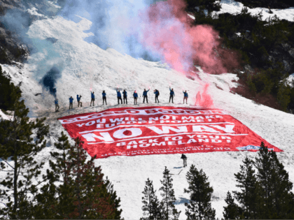 Activists with flares standing above banner
