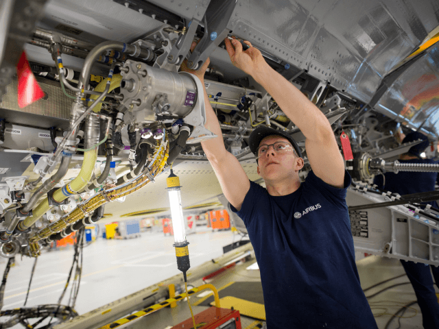 BRISTOL, ENGLAND - NOVEMBER 19: A skilled fitter works on the spoiler of a A400M at the Airbus aircraft manufacturer's Filton site on November 19, 2015 in Bristol, England. The site at Filton's main role is the designing and manufacture of wings, fuel and landing gear systems for all ranges …