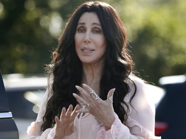 Singer and actress Cher stops to talk to media as she leaves a fundraiser for Democratic p