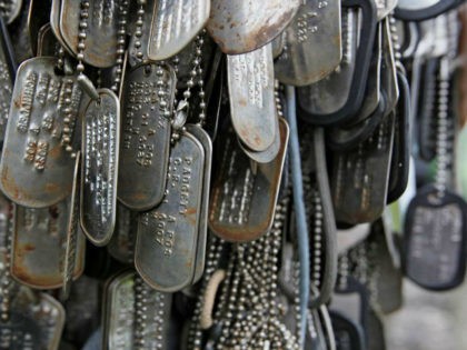 Dog tags hang from a memorial on the summit of Mt. Suribachi, on Iwo Jima, now known officially as Ioto, Japan, Friday, June 7, 2013. Iwo Jima, one of the most iconic battlegrounds of WWII, is today inhabited only by Japanese troops, and is used by the U.S. military for …