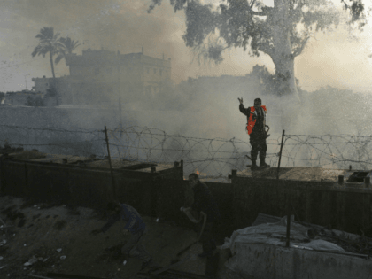 Palestinians Firefighters hose down a fire in Egypt, as they work over the separation fenc