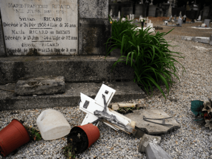 A photo taken on April 15, 2015 shows a crucifix on the floor after tombstones were found vandalized at the Saint-Roch cemetery in Castres, southern France. French President Francois Hollande condemned 'in the strongest terms' the vandalism of 'dozens of Christian tombs' at the Saint-Roch cemetery, qualifying the acts as …
