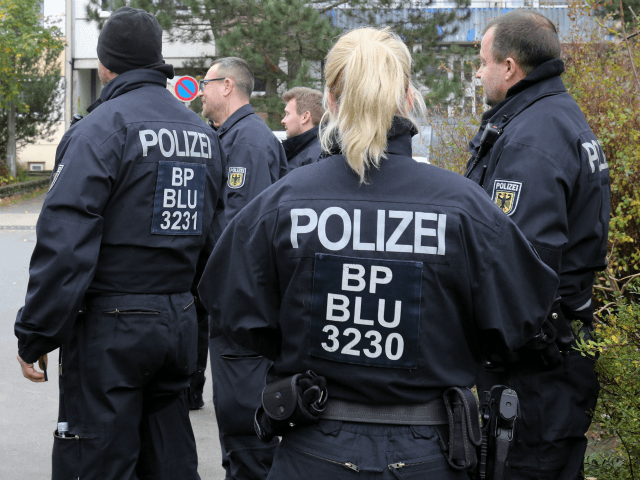 Policemen stand in front of a house at the Neu Zippendorf district in Schwerin, northeaste