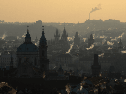 Smoke rises over the rooftops of central Prague with the Saint-Nicolas Church (L) during the sunrise on February 26, 2018, as the temperatures dropped to minus 12 degrees Celsius in the Czech capital. A wintry blast of freezing temperatures sweeps across Europe, with a biting wind from Siberia. The 'Beast …