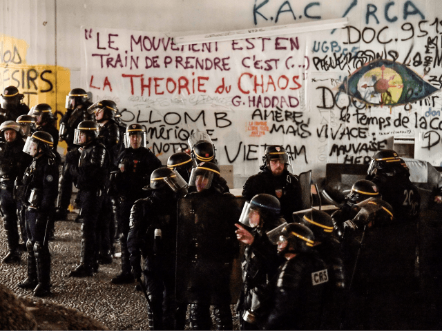 TOPSHOT - French anti-riot policemen stand together after breaking up a protest camp at th