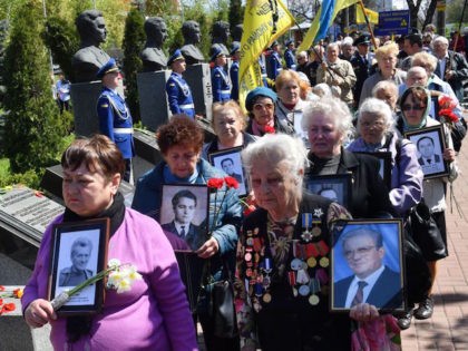 Widows carry the pictures of their late husbands, who were "liquidators" in Chernobyl, during a ceremony in tribute to the victims of the Chernobyl nuclear disaster which occured 32 years ago, at a memorial to victims in Kiev, on April 26, 2018. - The accident spread radioactive fallout across Europe …