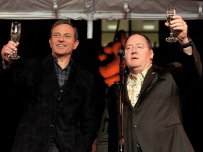 Bob Iger, Chairman and CEO, The Walt Disney Company (L) and John Lasseter, Chief Creative Officer, Pixar and Walt Disney Animation Studios toast the gusets at a reception to celebrate 90 Years of Disney animation at The Walt Disney Studios on December 10, 2013 in Burbank, California. (Photo by Kevin …