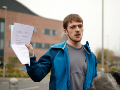 LIVERPOOL, ENGLAND - APRIL 13: Tom Evans, the father of terminally ill 23-month-old Alfie Evans, holds up a court order as he speaks to the media outside Alder Hey Hospital where Alfie is being cared for on April 13, 2018 in Liverpool, England. Tom Evans and Kate James the parents …