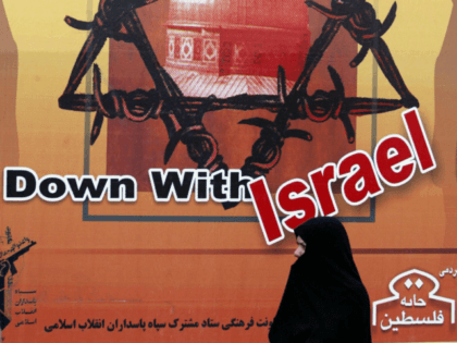 TEHRAN, IRAN: An Iranian woman passes by an anti-Israeli slogan under a star of David duri