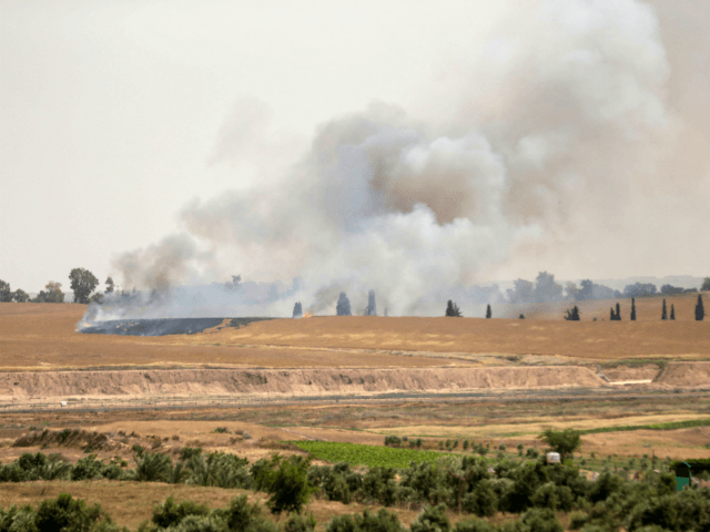 Smoke and flames rise from fields near the Kibbutz Beeri on the Israeli side of the border