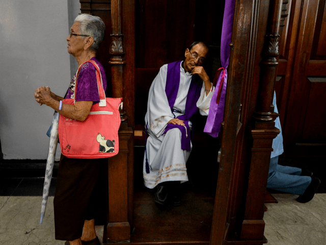Catholic faithful wait their turn for confession at Santa Teresa basilica in Caracas during the celebration of the Nazarene of Saint Paul, part of the Holy Week festivities, on April 12, 2017. / AFP PHOTO / FEDERICO PARRA (Photo credit should read FEDERICO PARRA/AFP/Getty Images)