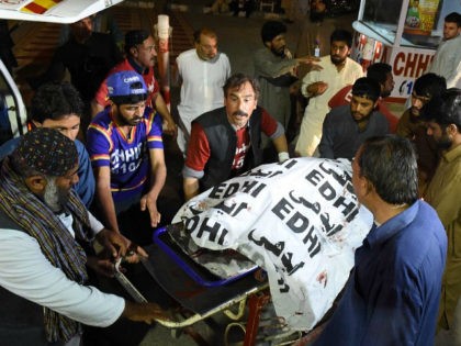 Pakistani volunteers move the body of a Christian resident killed in an attack by gunmen t