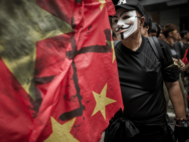 A man wears a mask of the Anonymous hacker group as he and other people take part in a pro
